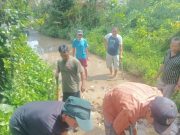 Masyarakat Gotong Royong Timbun Jalan Yang Tergenang Air